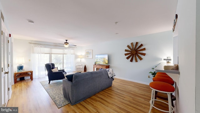 living room featuring ceiling fan and light wood-type flooring