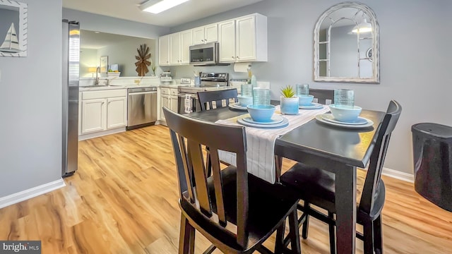 dining room with light wood-type flooring and sink