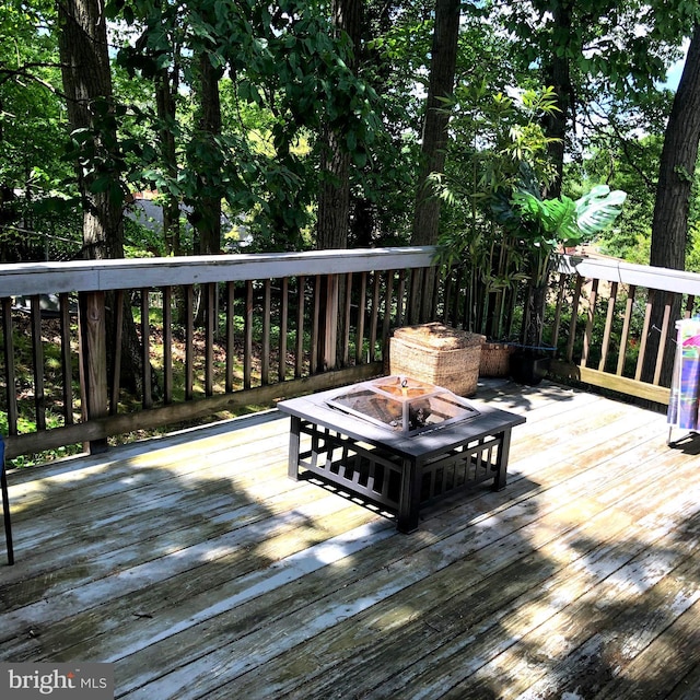 wooden terrace featuring an outdoor fire pit