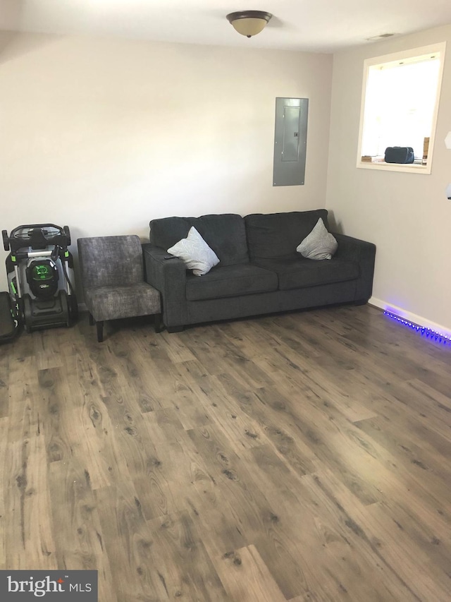 living room with dark wood-type flooring and electric panel