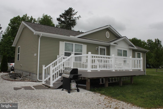 single story home with a front lawn and a wooden deck