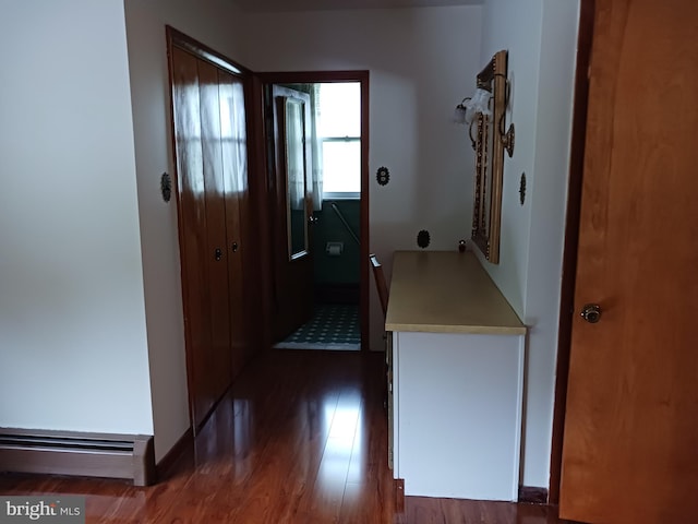 hallway featuring dark wood-type flooring and a baseboard radiator