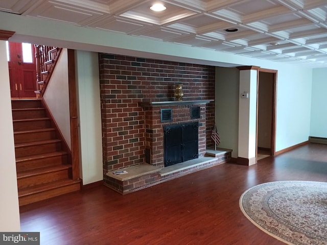 unfurnished living room featuring coffered ceiling, beam ceiling, dark hardwood / wood-style flooring, and a brick fireplace