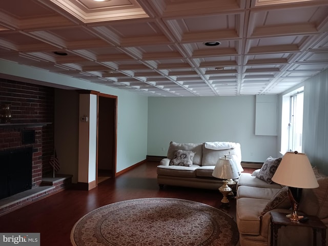 living room with coffered ceiling, a baseboard heating unit, a brick fireplace, beam ceiling, and dark hardwood / wood-style flooring