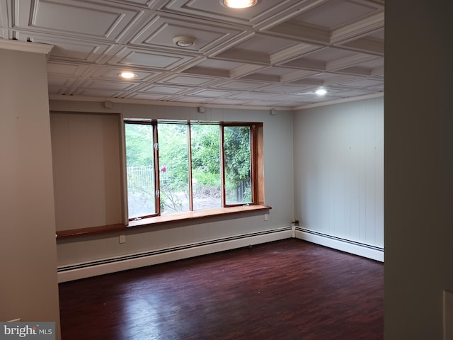 empty room featuring coffered ceiling, dark wood-type flooring, and a baseboard heating unit