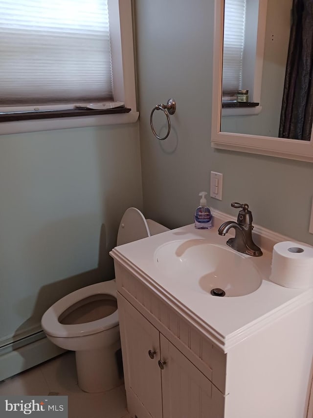 bathroom with tile patterned flooring, vanity, toilet, and baseboard heating