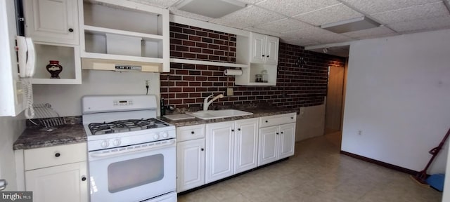 kitchen featuring a drop ceiling, white appliances, sink, white cabinets, and range hood