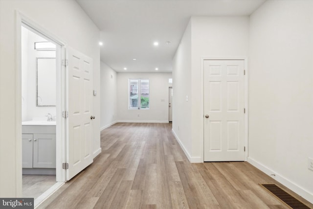 hall featuring light hardwood / wood-style floors and sink