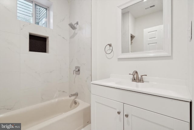 bathroom with vanity and tiled shower / bath