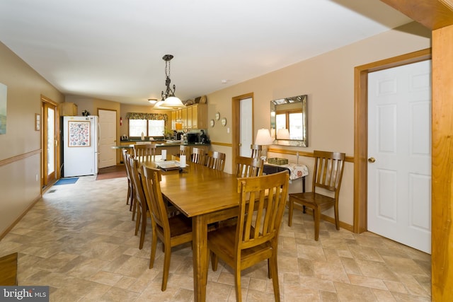 dining area featuring an inviting chandelier and light tile flooring