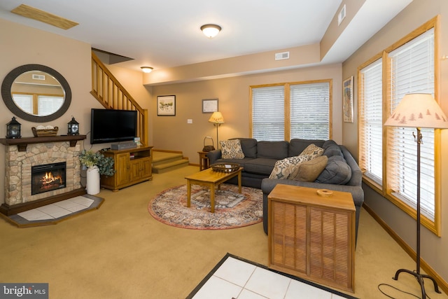 living room featuring a stone fireplace and tile floors