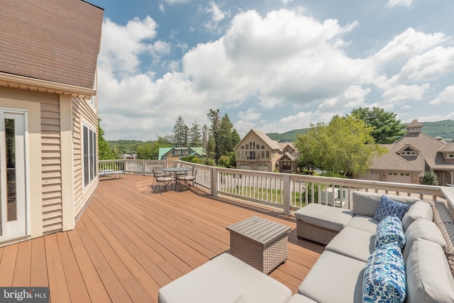 wooden terrace with an outdoor living space