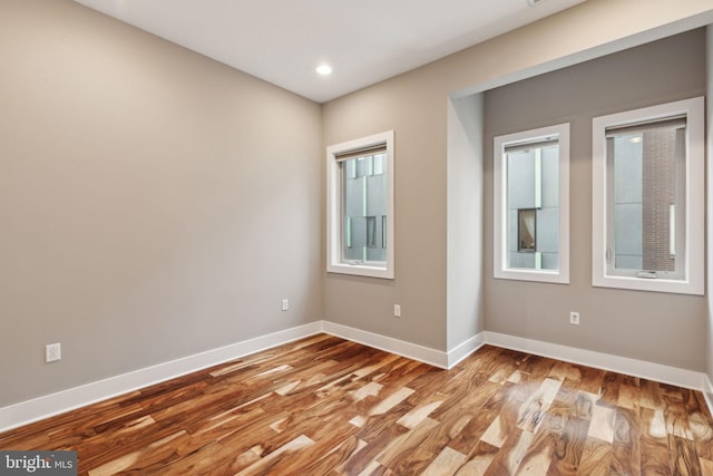 spare room with light wood-type flooring and plenty of natural light