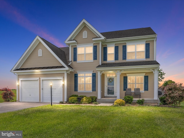 view of front of home with a garage and a lawn