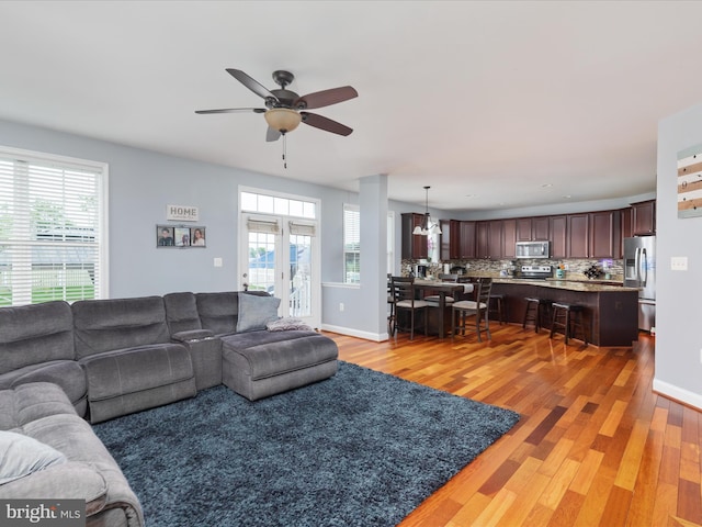 living room with light hardwood / wood-style floors, french doors, and ceiling fan