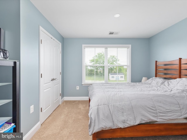 bedroom with light carpet and a closet