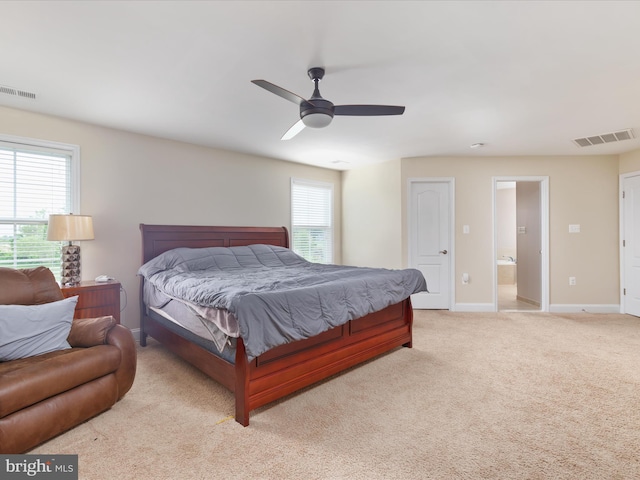 carpeted bedroom featuring ceiling fan and ensuite bath