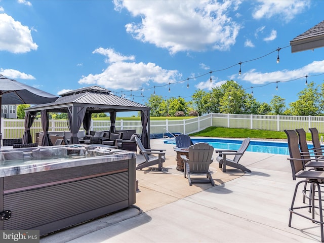 view of swimming pool featuring a fire pit, a gazebo, a hot tub, and a patio