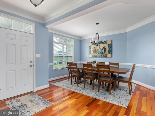 dining space featuring a notable chandelier, hardwood / wood-style floors, and crown molding