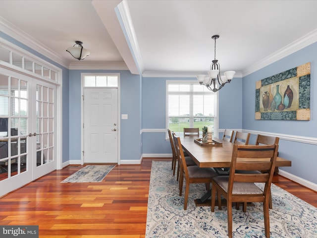 dining space with plenty of natural light, ornamental molding, hardwood / wood-style floors, and a chandelier