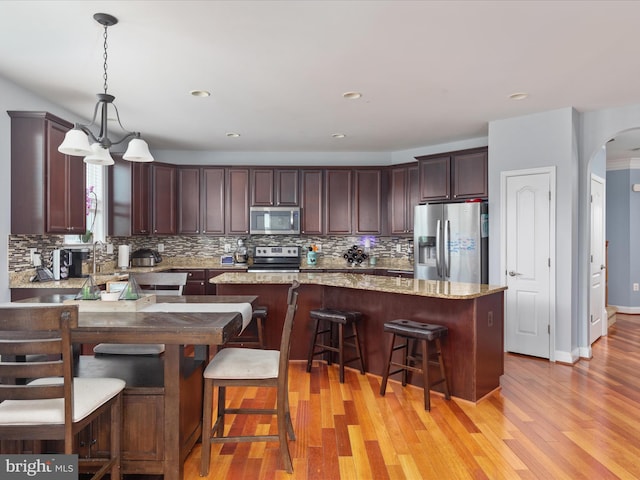 kitchen featuring light hardwood / wood-style floors, a kitchen island, and stainless steel appliances