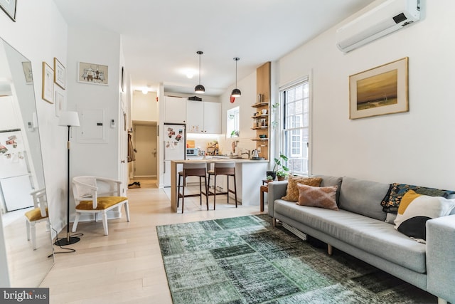 living room featuring light wood-type flooring and a wall mounted air conditioner