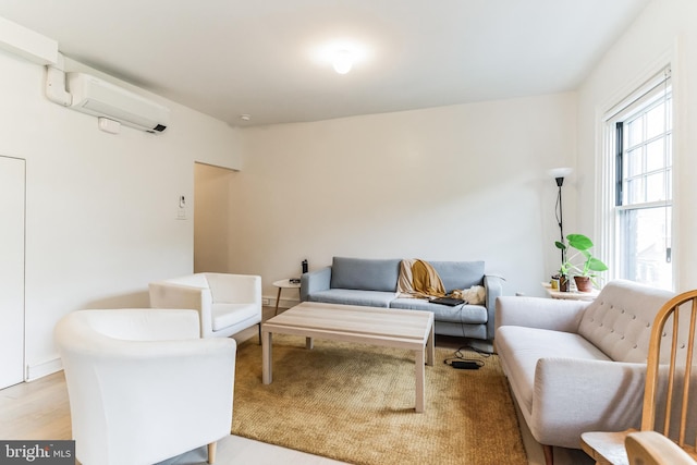 living room featuring a wall unit AC and light wood-type flooring