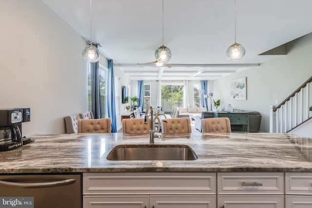 kitchen featuring white cabinetry, hanging light fixtures, sink, and ceiling fan