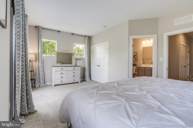 carpeted bedroom featuring sink and connected bathroom