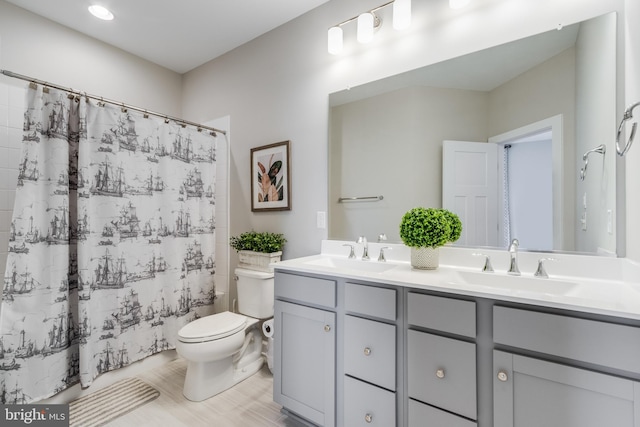 bathroom with double vanity and toilet