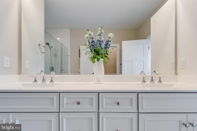 bathroom with double sink, a shower with door, and large vanity