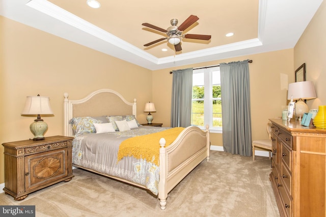 bedroom with ceiling fan, a tray ceiling, carpet floors, and crown molding