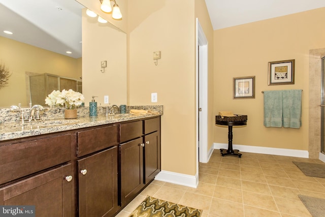 bathroom with tile floors, a shower with door, and double vanity