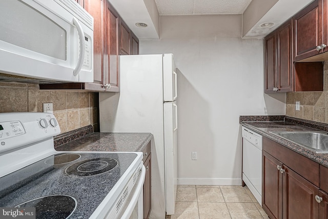 kitchen with sink, white appliances, light tile flooring, and tasteful backsplash