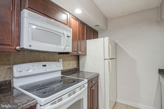 kitchen with white appliances, backsplash, and light tile floors