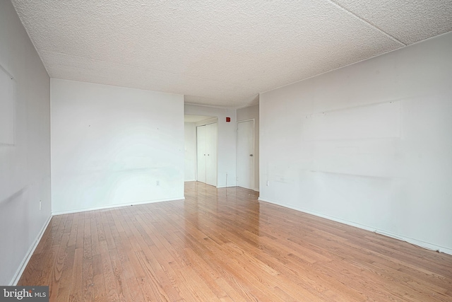 unfurnished room with light hardwood / wood-style floors and a textured ceiling