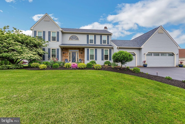 view of front of property featuring a front yard and a garage