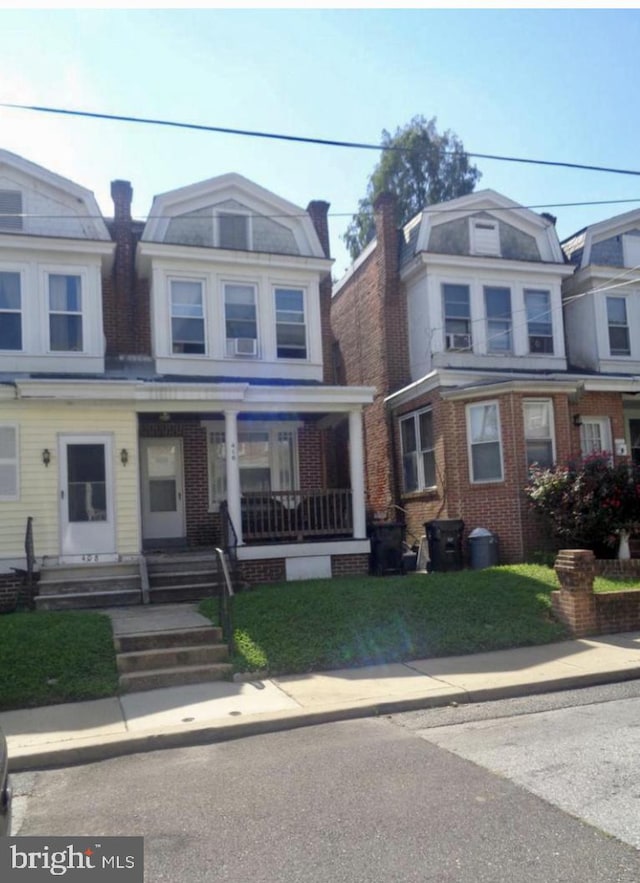 view of front of property featuring a front yard and covered porch