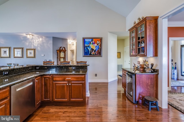 kitchen with dark hardwood / wood-style floors, dishwasher, vaulted ceiling, and dark stone countertops