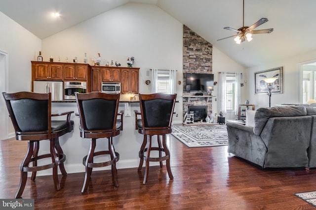 kitchen with high vaulted ceiling, stainless steel appliances, and dark wood-type flooring