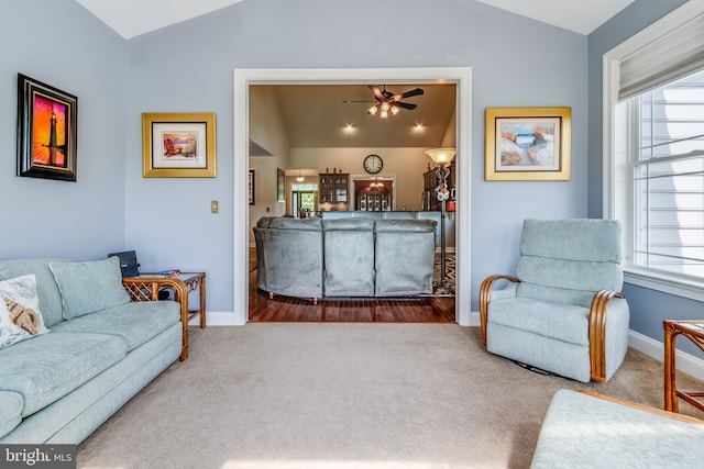 living room featuring ceiling fan, carpet floors, and lofted ceiling