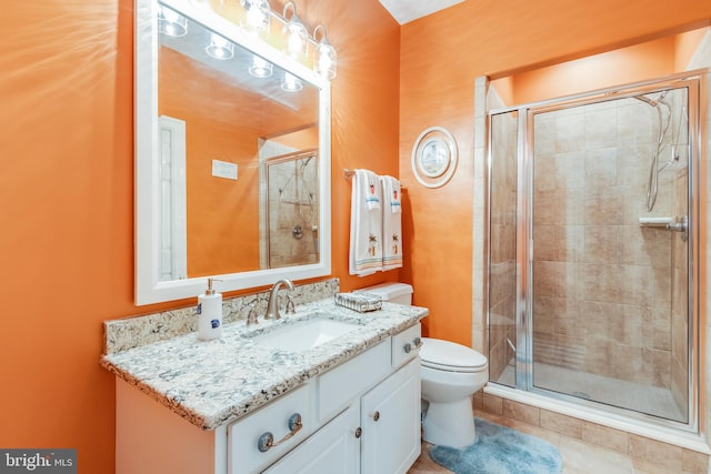 bathroom featuring a shower with shower door, tile flooring, toilet, and large vanity