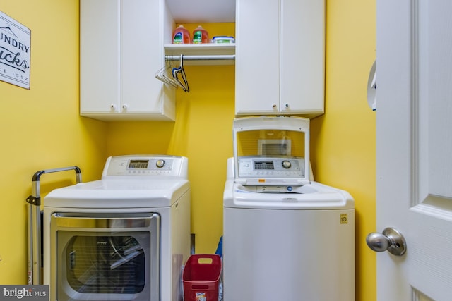 laundry area featuring washer and dryer and cabinets