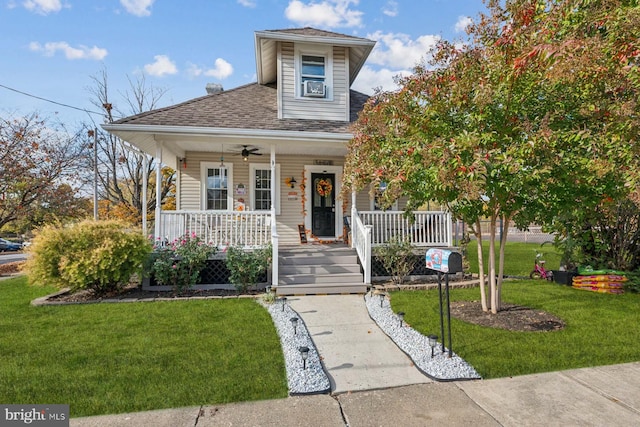 view of front facade with a porch, a front yard, and ceiling fan