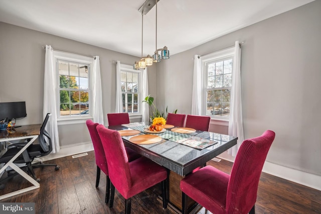 dining space featuring dark wood-type flooring and a healthy amount of sunlight