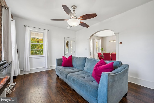 living room with dark wood-type flooring and ceiling fan