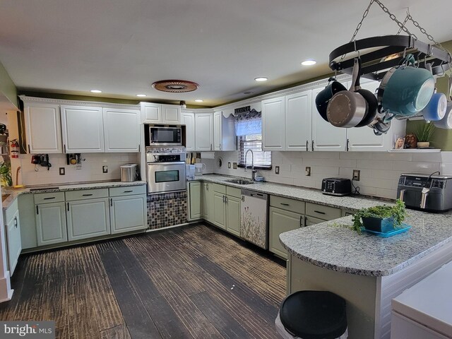 kitchen featuring white cabinets, appliances with stainless steel finishes, kitchen peninsula, and sink