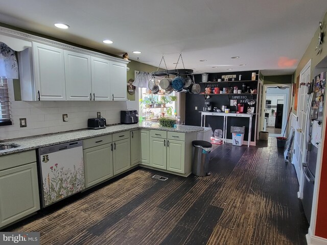 kitchen with light stone countertops, dishwasher, dark wood-type flooring, tasteful backsplash, and kitchen peninsula