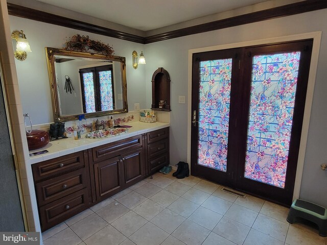 bathroom featuring vanity, tile patterned floors, and crown molding