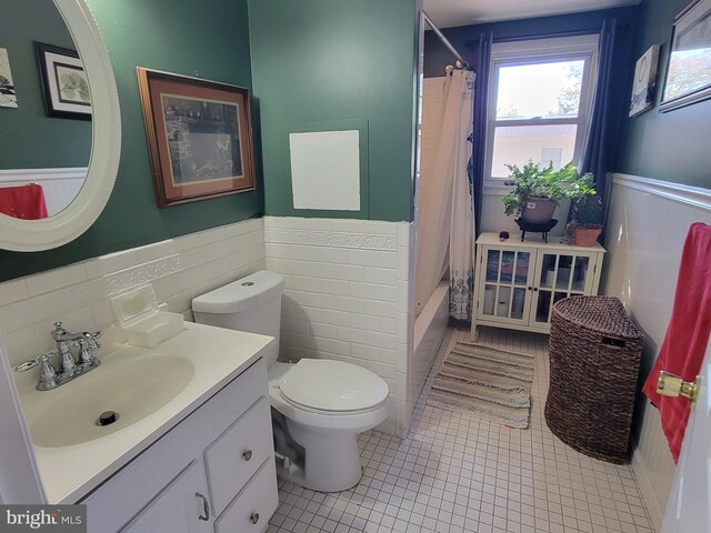 full bathroom featuring shower / tub combo, tile patterned floors, vanity, tile walls, and toilet